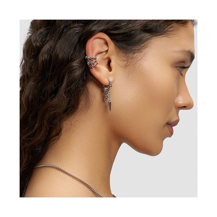 Nærbillede af kvindes øre med Liebeskind smykkesæt i rustfrit stål: ørering, ear cuff, halskæde med skarpt vedhæng.