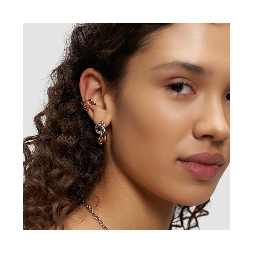 Nærbillede af en kvinde med et flerfarvet Liebeskind sæt af øreringe og earcuffs i rustfrit stål.
