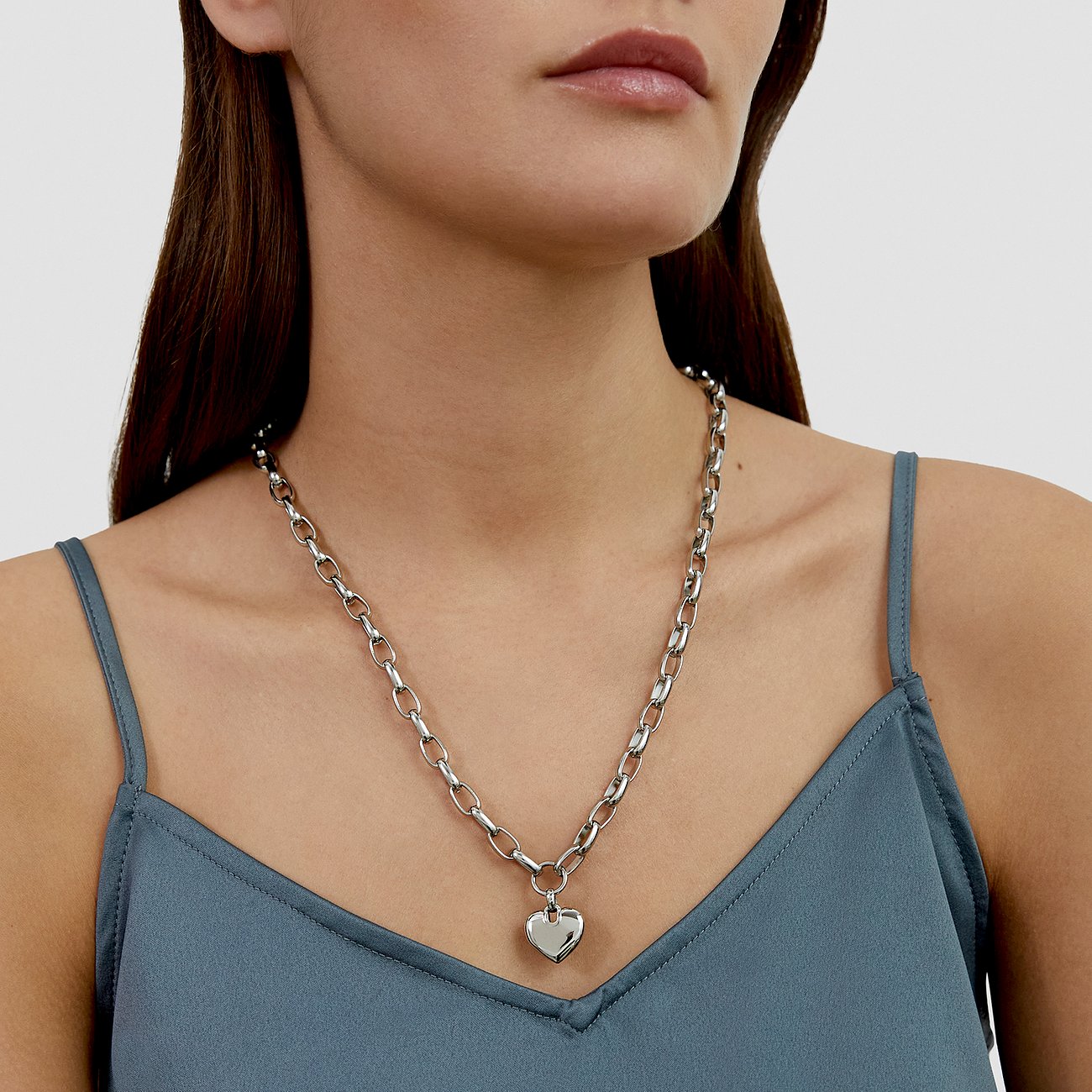 s.Oliver halsband i rostfritt stål med ett glänsande hjärtformat hänge, buret av en modell.