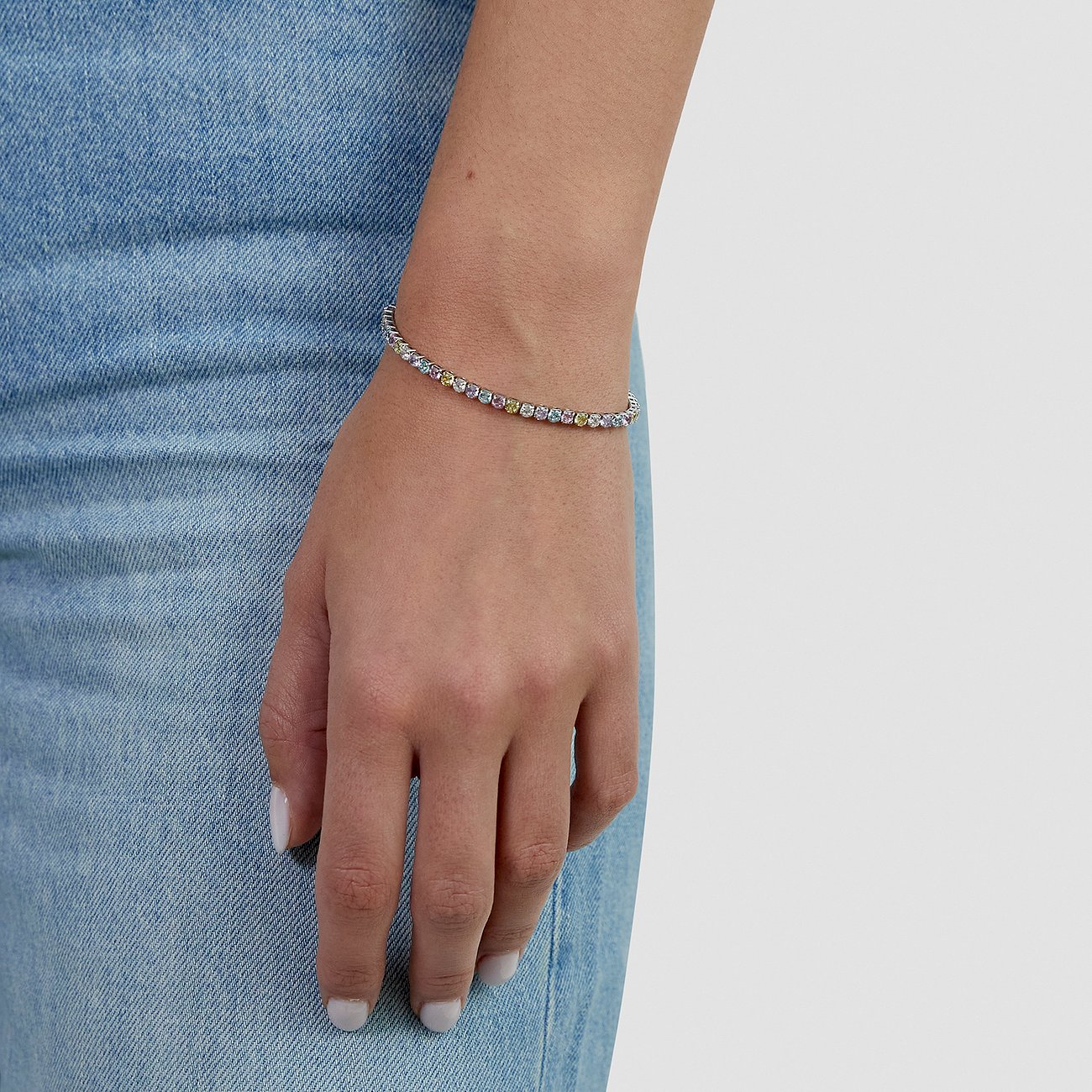 Bracelet s.Oliver en acier inoxydable avec pierres de zircone colorées, porté au poignet d'un modèle.