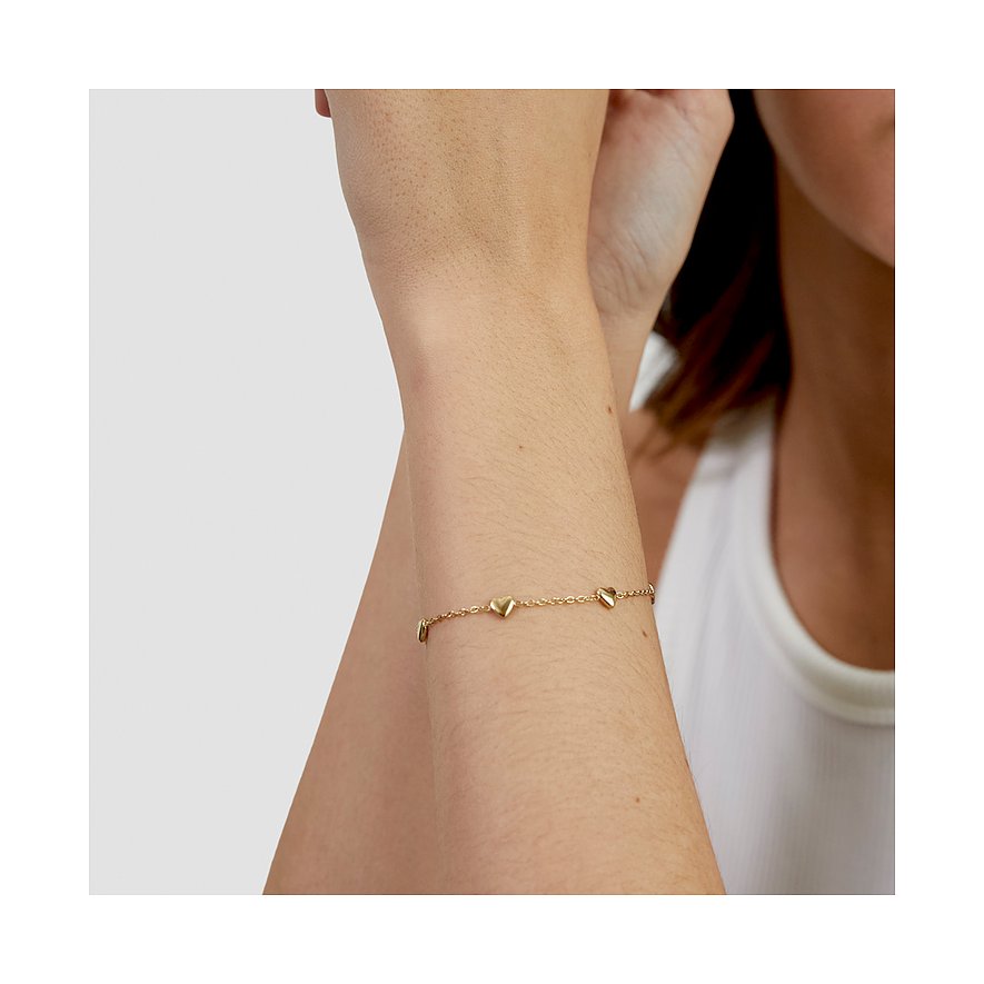 Bracelet cœur s.Oliver en acier inoxydable doré au poignet d'un mannequin