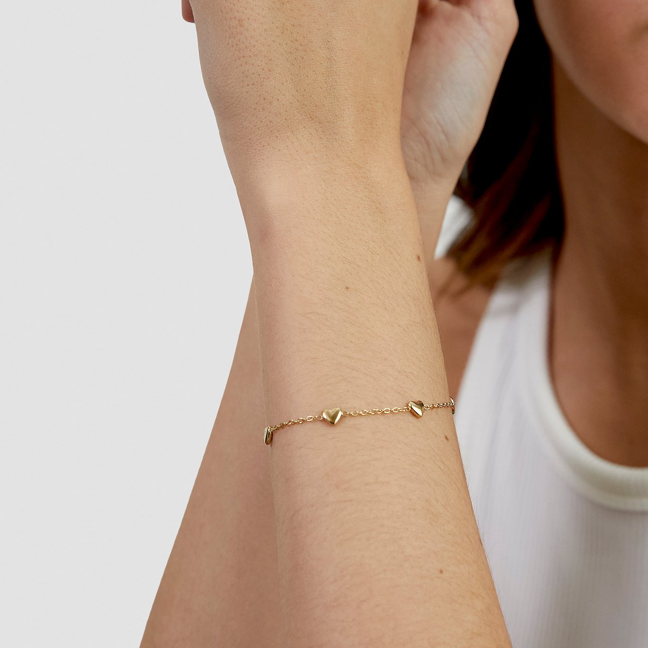 Bracelet cœur s.Oliver en acier inoxydable doré au poignet d'un mannequin