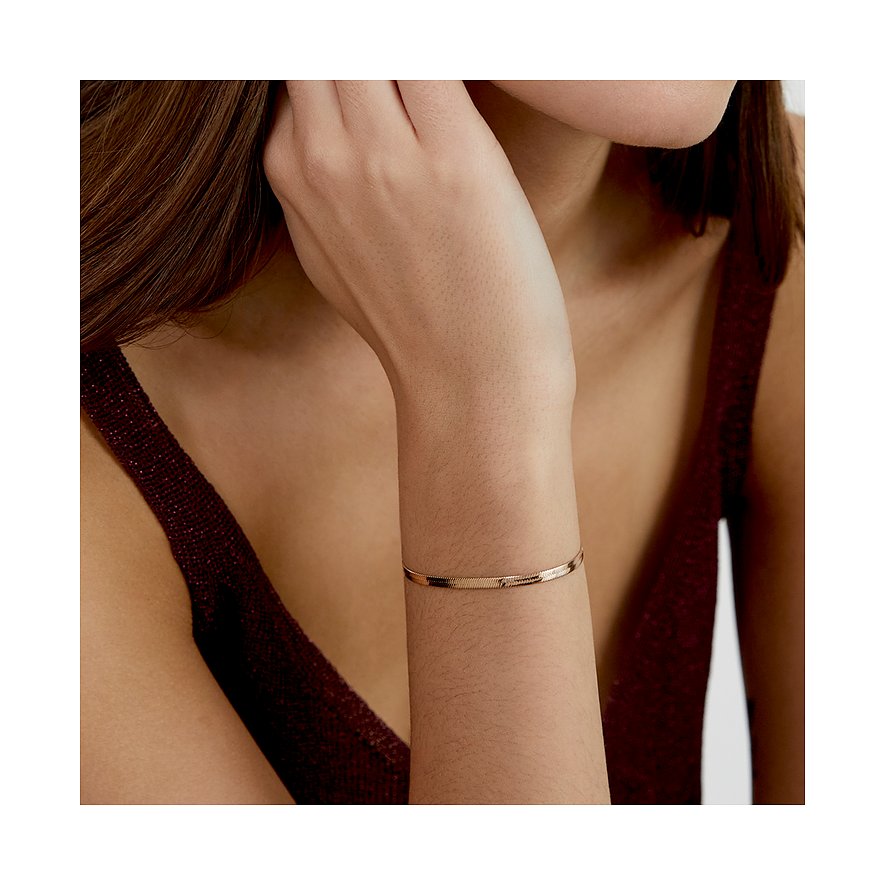 s.Oliver Armschmuck aus rosegoldfarbenem Edelstahl als Schlangenkettenarmband am Handgelenk einer Frau.