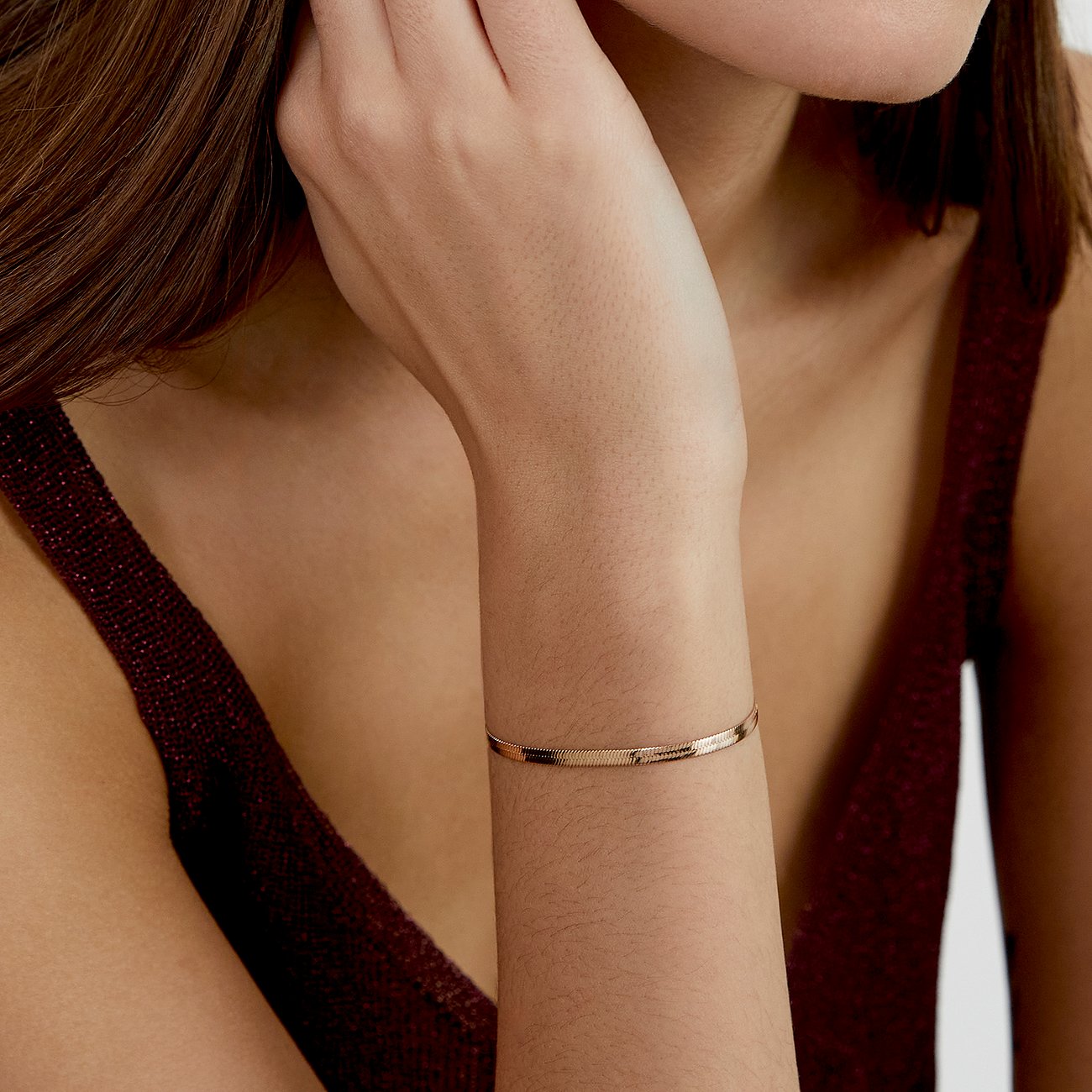 s.Oliver Armschmuck aus rosegoldfarbenem Edelstahl als Schlangenkettenarmband am Handgelenk einer Frau.