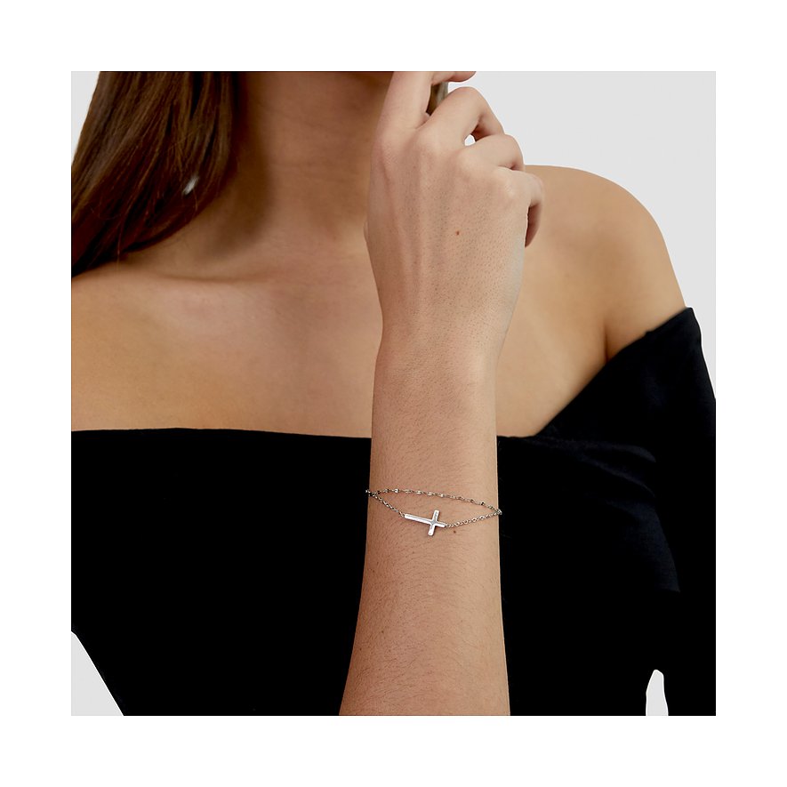 Am Handgelenk einer Frau ist ein s.Oliver Armschmuck aus Edelstahl mit Kreuz-Anhänger zu sehen.