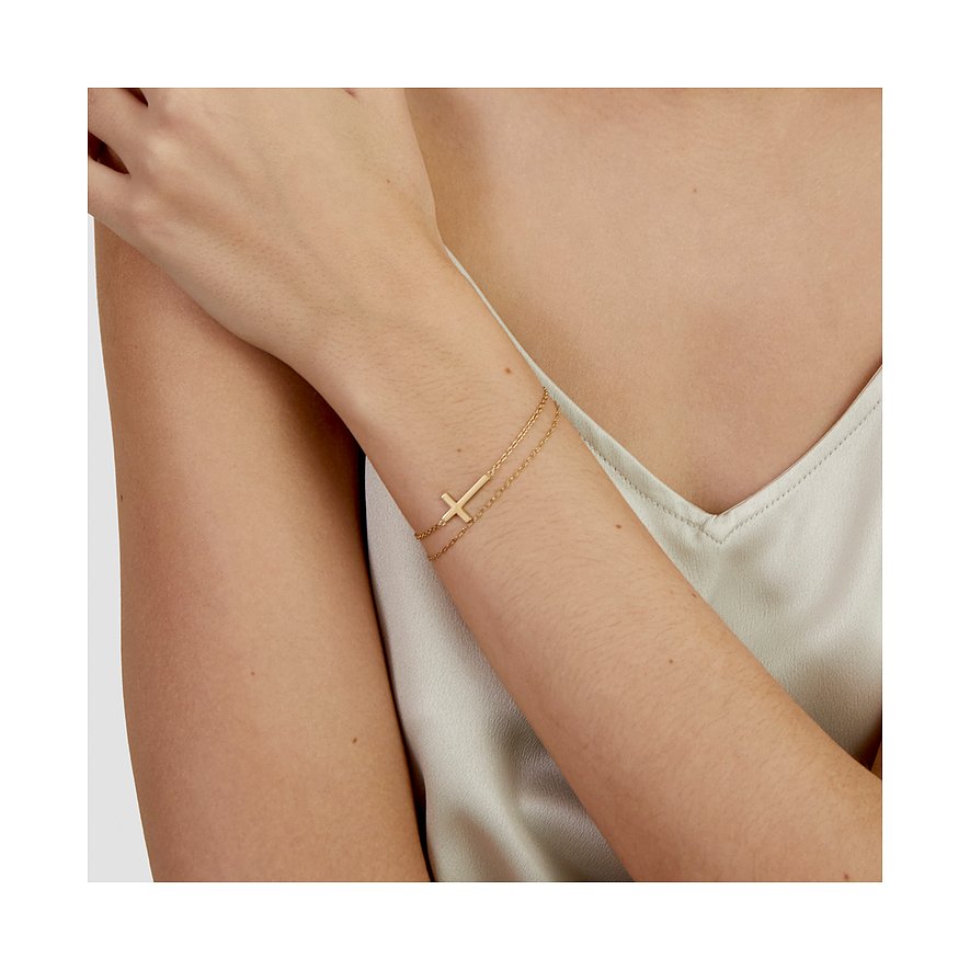 Am Handgelenk getragenes s.Oliver Armband aus goldfarbenem Edelstahl mit zwei Ketten und einem seitlichen Kreuzanhänger.