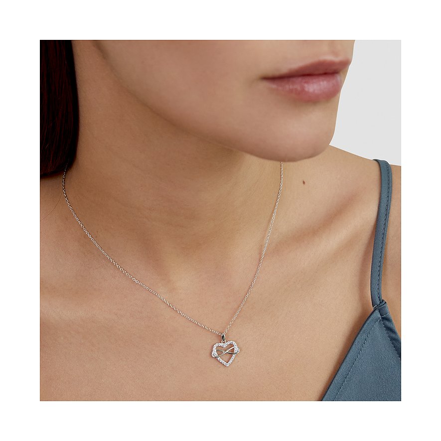 En kvinna bär ett silverfärgat s.Oliver-halsband med ett hjärtformat hänge, dekorerat med zirkoniafärgade stenar.
