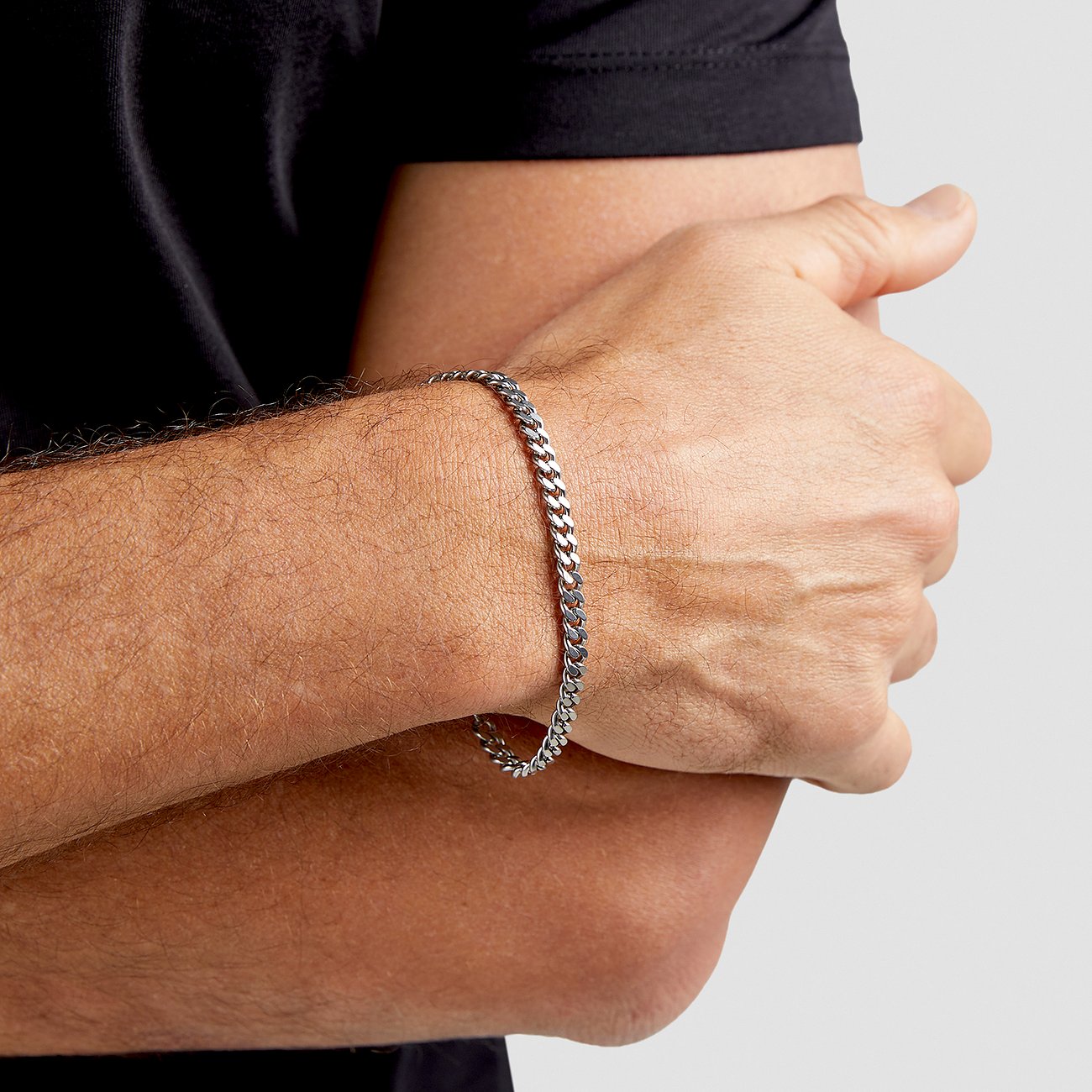 Am Arm des Models ist ein s.Oliver Armband aus glänzendem Edelstahl zu sehen.