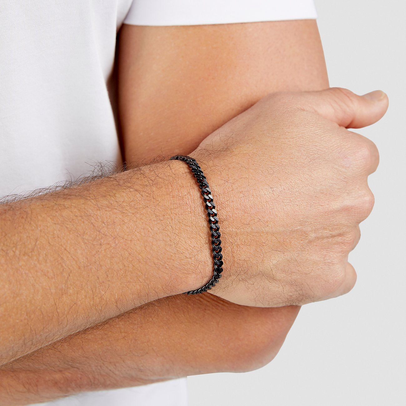 Am Handgelenk eines Mannes getragenes s.Oliver Armband aus schwarzem Edelstahl mit Panzerkette.