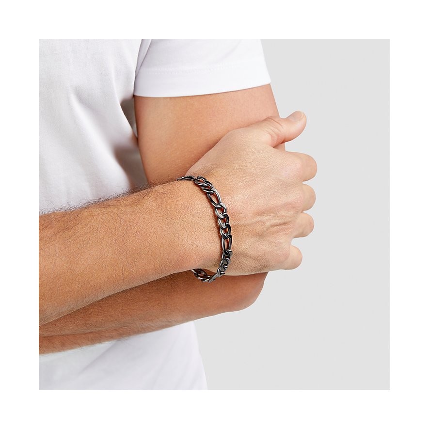 En man med ett s.Oliver armband i pansarkedjedesign av mörkt rostfritt stål på sin underarm.