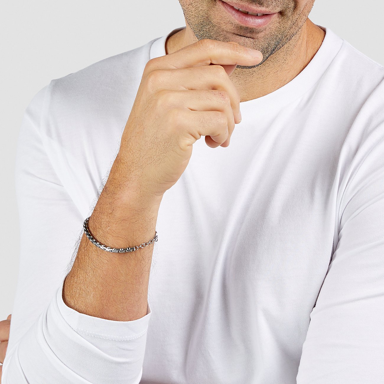 Un uomo con un bracciale s.Oliver in acciaio inossidabile al polso, che guarda in lontananza.
