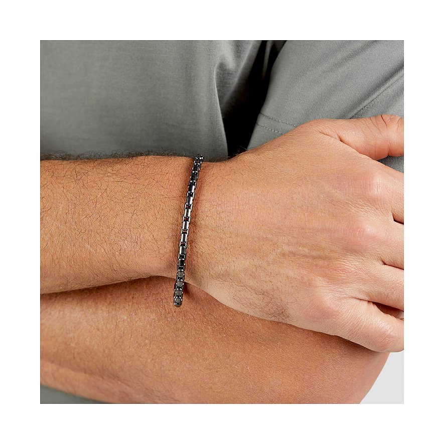 Ett s.Oliver armband i mörkt rostfritt stål med glänsande länkar syns på en mans handled.