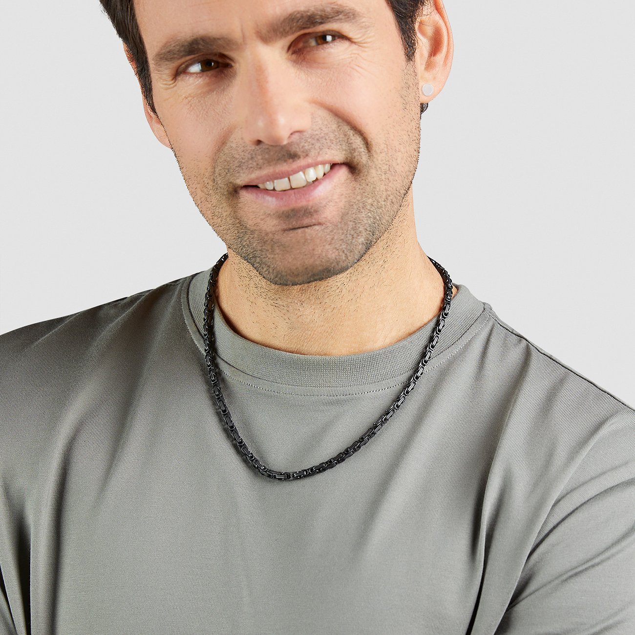 Un homme souriant porte le collier s.Oliver en acier inoxydable noir, design 