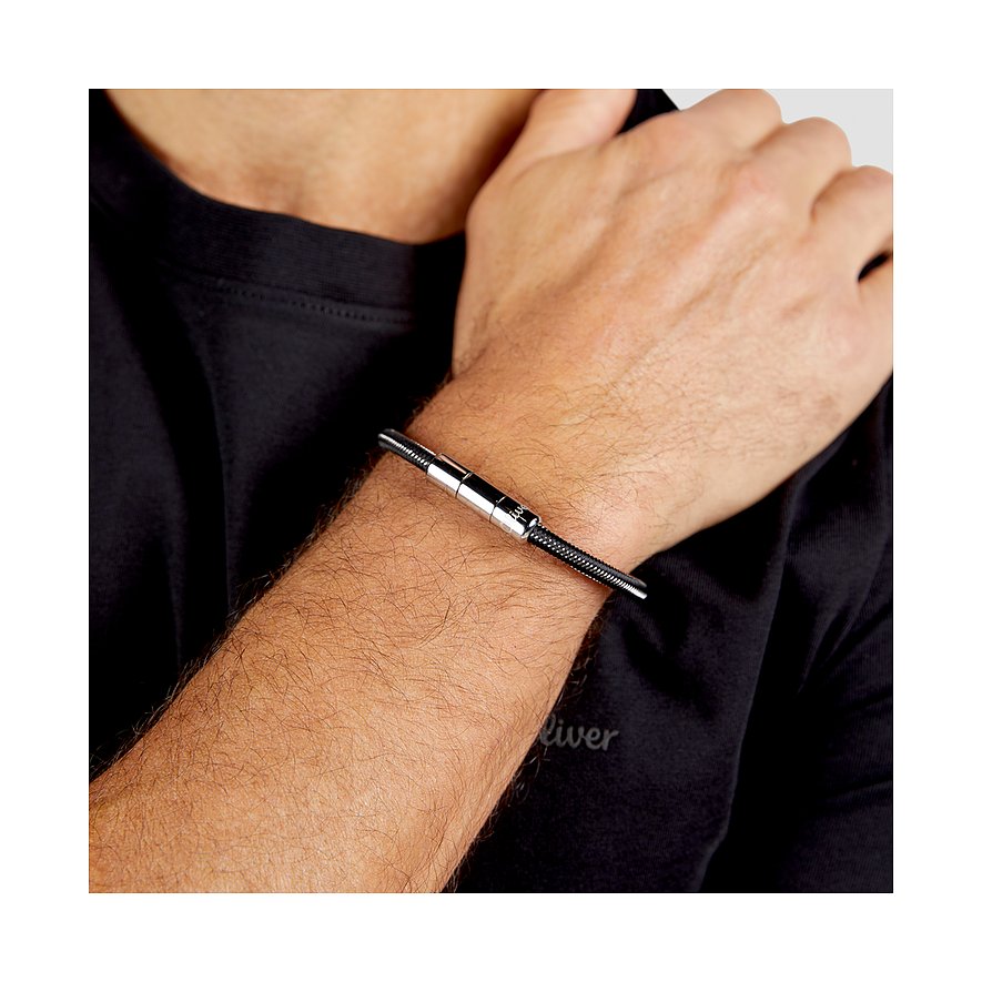 Ein s.Oliver Herren-Armband aus Edelstahl am Handgelenk eines Mannes, mit einem silbernen Mittelstück.
