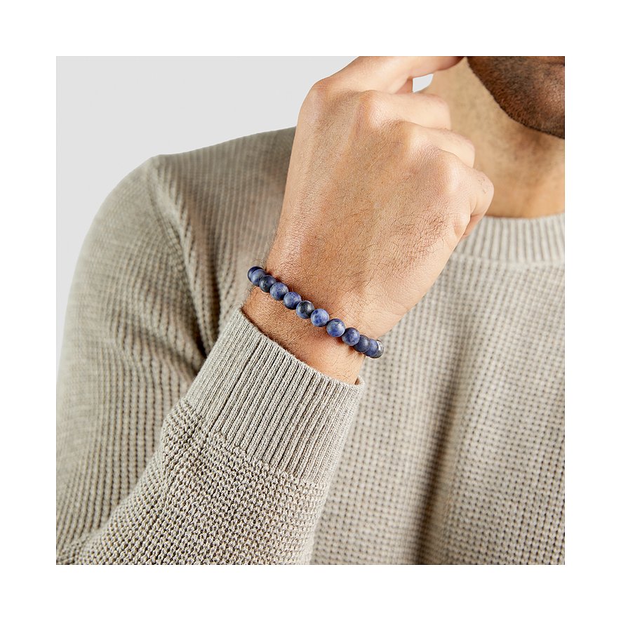Un bracelet pour homme s.Oliver en pierres bleues, porté au poignet d'un homme.