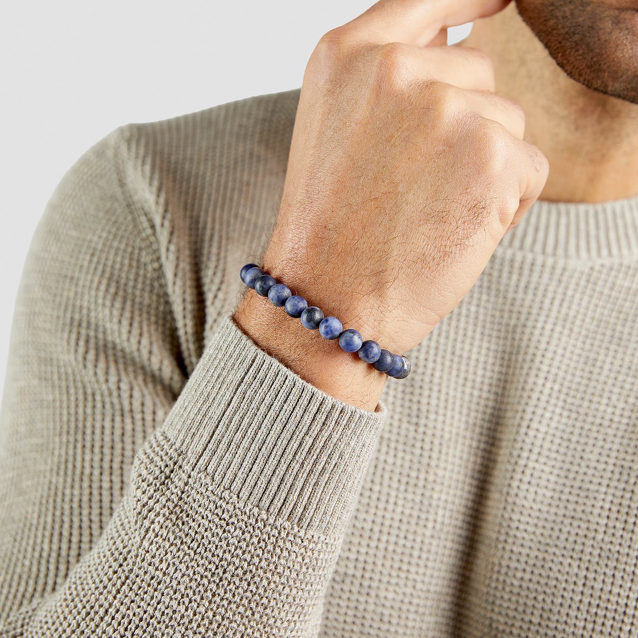 Un bracelet pour homme s.Oliver en pierres bleues, porté au poignet d'un homme.