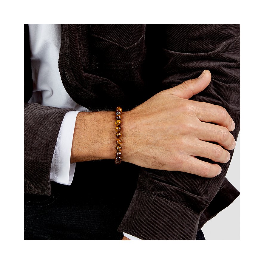 Bracciale uomo s.Oliver in pietre occhio di tigre marroni, indossato su un braccio con giacca scura e camicia bianca.