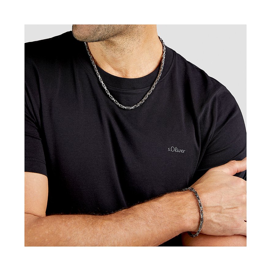 Ein Mann trägt eine s.Oliver Halskette und ein passendes Armband aus Edelstahl über einem schwarzen T-Shirt.