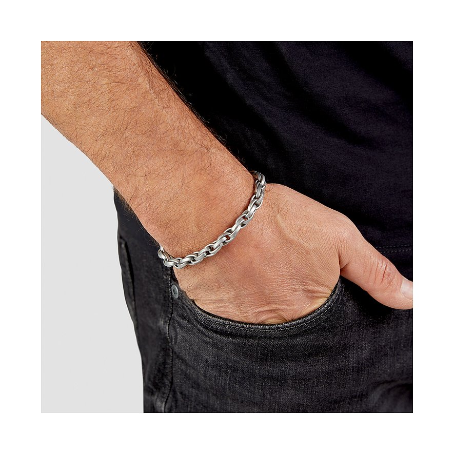 s.Oliver Armschmuck aus mattem Edelstahl als Gliederkette, von einem männlichen Arm getragen mit Hand in Hosentasche.