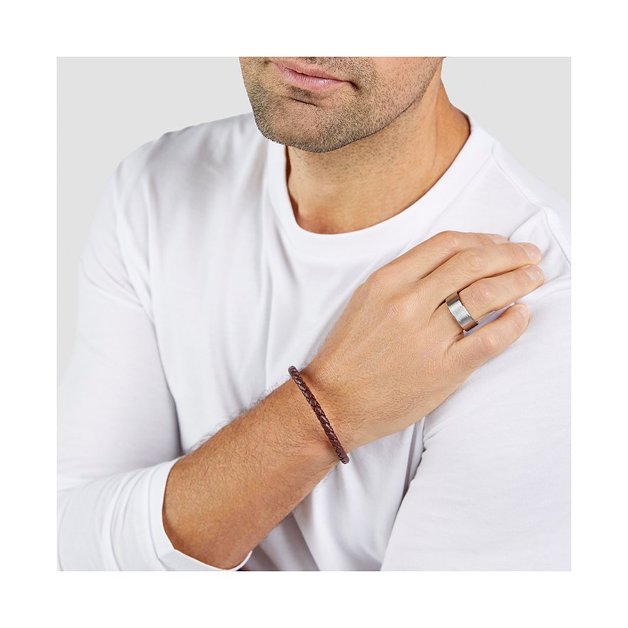 Nahaufnahme eines Mannes, der ein s.Oliver Armschmuck aus geflochtenem braunem Leder trägt.