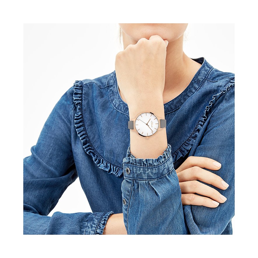 Gros plan sur la montre en métal s.Oliver pour femme, avec bracelet gris et cadran blanc, portée au poignet.