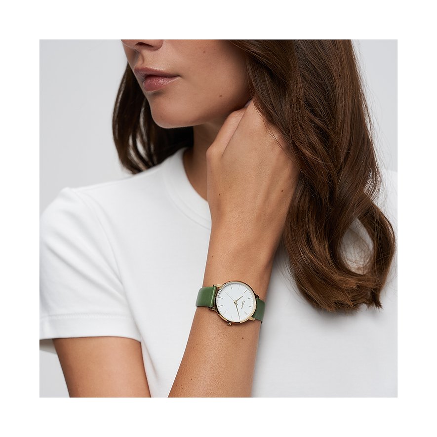 Nahaufnahme einer s.Oliver Damenuhr aus Metall am Handgelenk eines Models. Mattgrünes Lederarmband, weißes Zifferblatt.