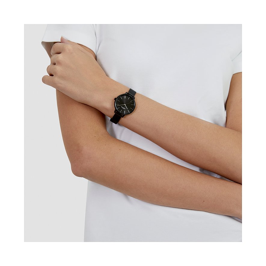 På en kvinnas handled syns en s.Oliver damklocka i metall med svart urtavla och armband.