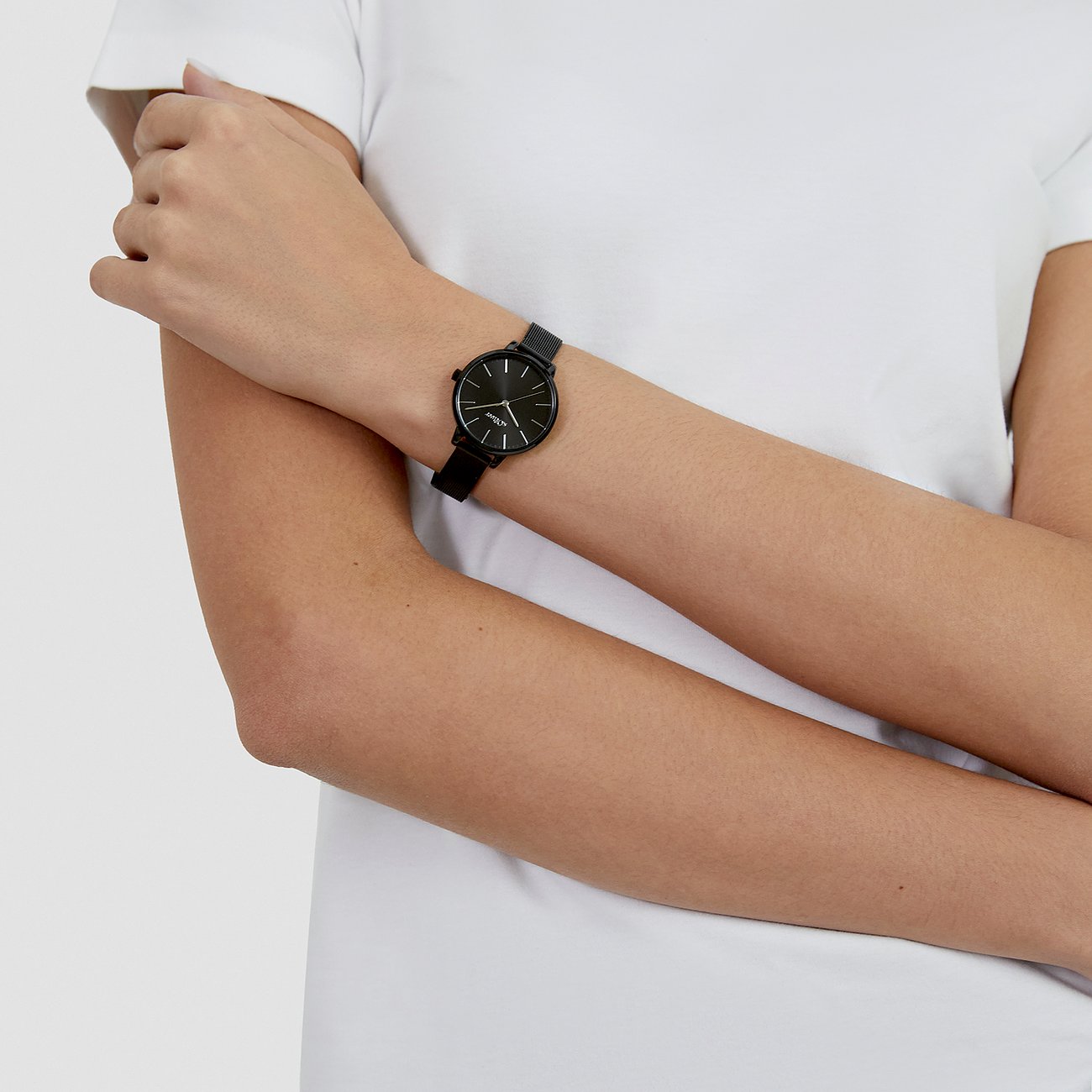 På en kvinnas handled syns en s.Oliver damklocka i metall med svart urtavla och armband.