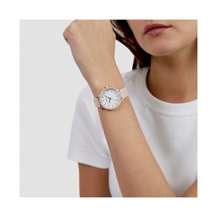 Femme porte une montre s.Oliver ronde en métal avec bracelet en acétate rose au poignet.