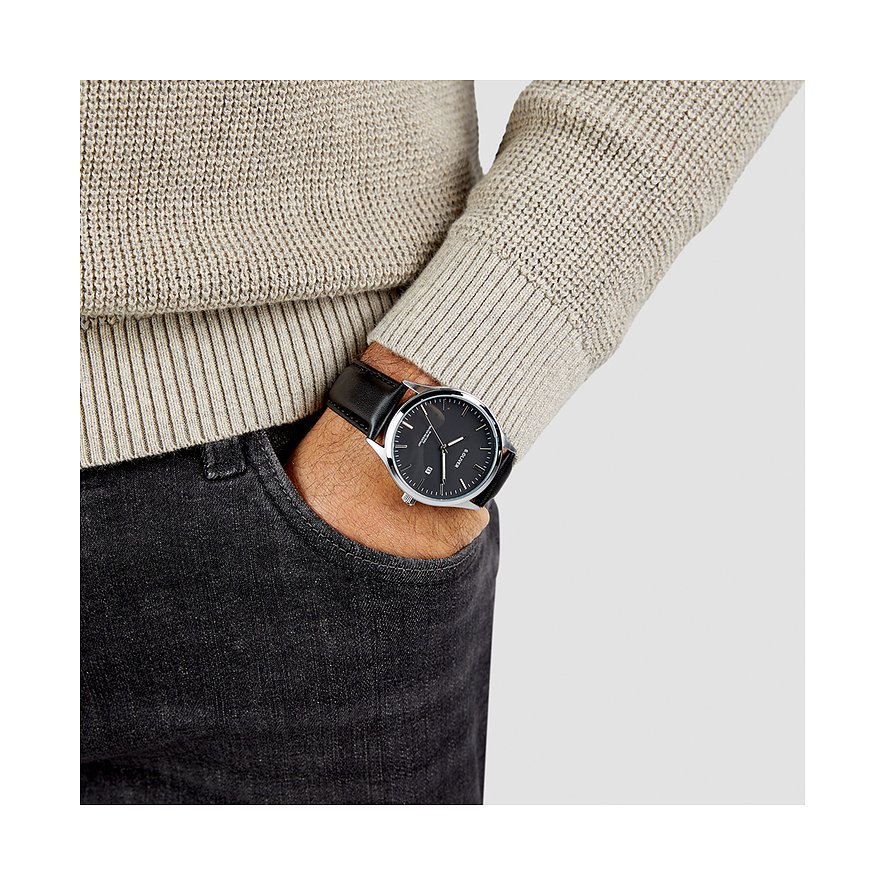 Ein Mann trägt eine s.Oliver Herrenuhr aus Metall mit schwarzem Zifferblatt und Lederarmband.