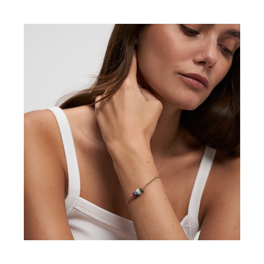 Délicat bracelet Tamaris en acier inoxydable doré avec trois perles colorées en aventurine au poignet d'une mannequin.