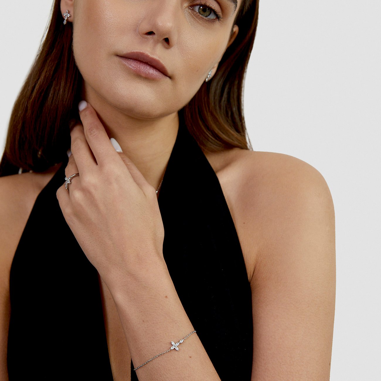 Ein Tamaris Armband aus Edelstahl mit Zirkonia-Farbsteinanhänger in Blumenform am Handgelenk eines Models.
