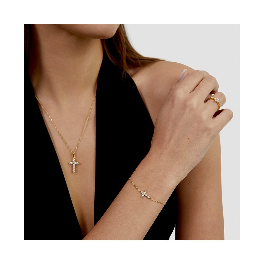 Model trägt Tamaris Armschmuck aus gelbvergoldetem Edelstahl, besetzt mit funkelnden Zirkonia-Farbsteinen.