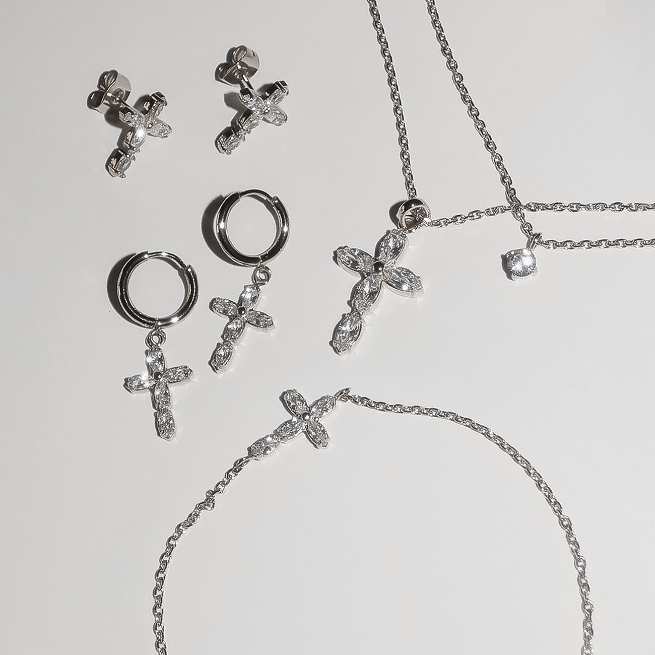 Tamaris Set: Ohrstecker, Creolen, Halskette, Armschmuck aus Edelstahl, besetzt mit Zirkonia in Kreuzform.