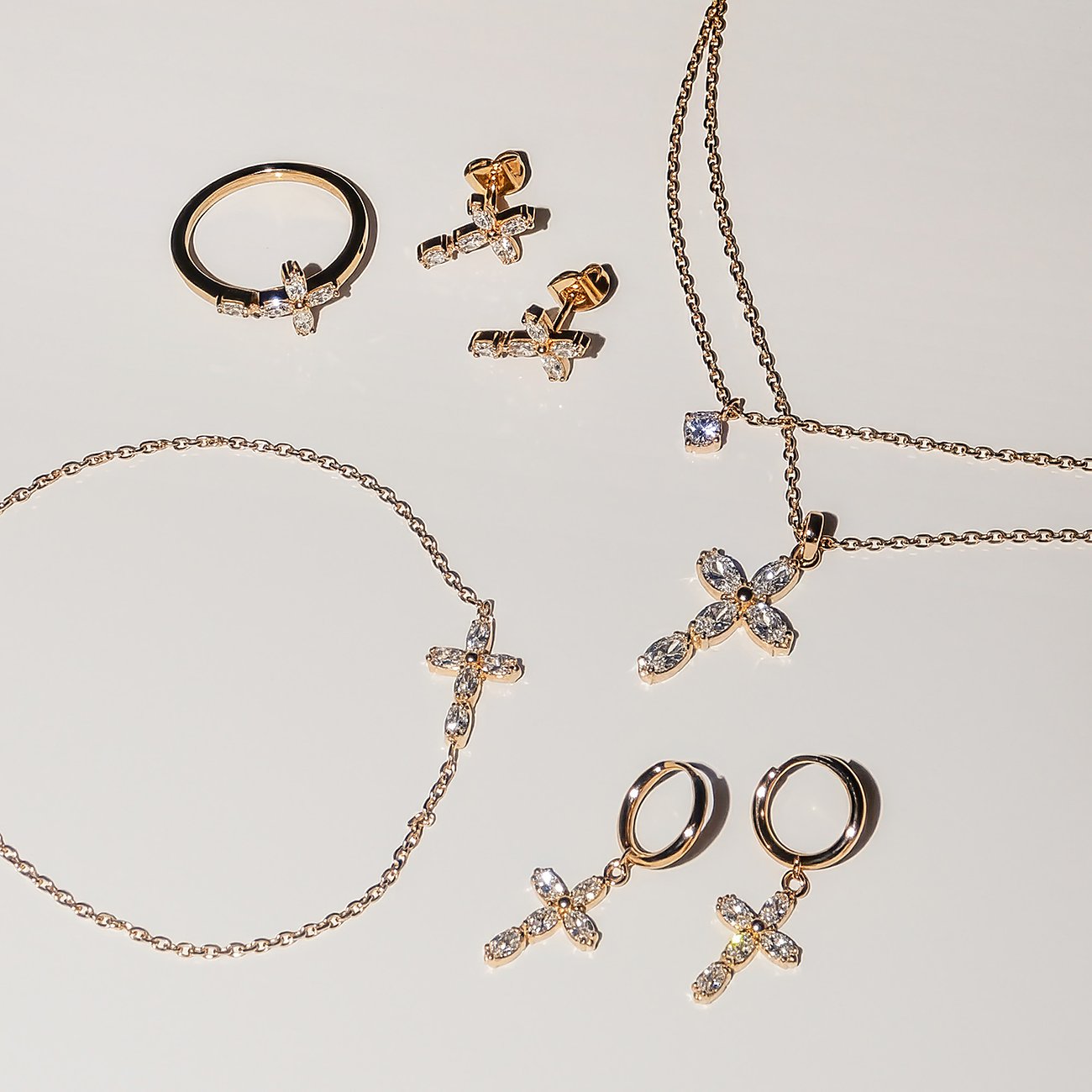 Tamaris Schmuckset aus goldenem Edelstahl: Ringe, Ohrringe, Halsketten mit funkelnden Zirkonia-Kreuzen.