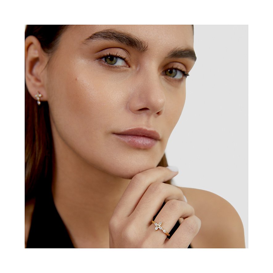 Model trägt einen goldfarbenen Tamaris-Edelstahlring mit Schmetterlingsmotiv und Zirkonia-Farbsteinen.