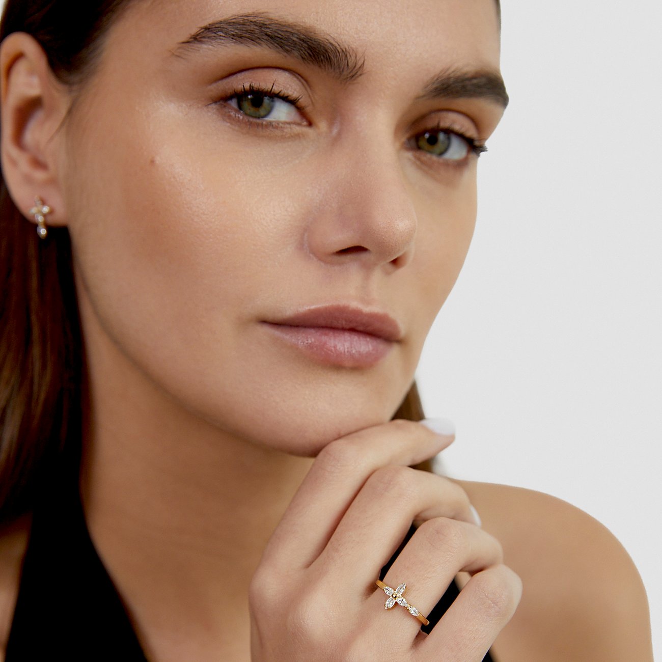 Model trägt einen goldfarbenen Tamaris-Edelstahlring mit Schmetterlingsmotiv und Zirkonia-Farbsteinen.