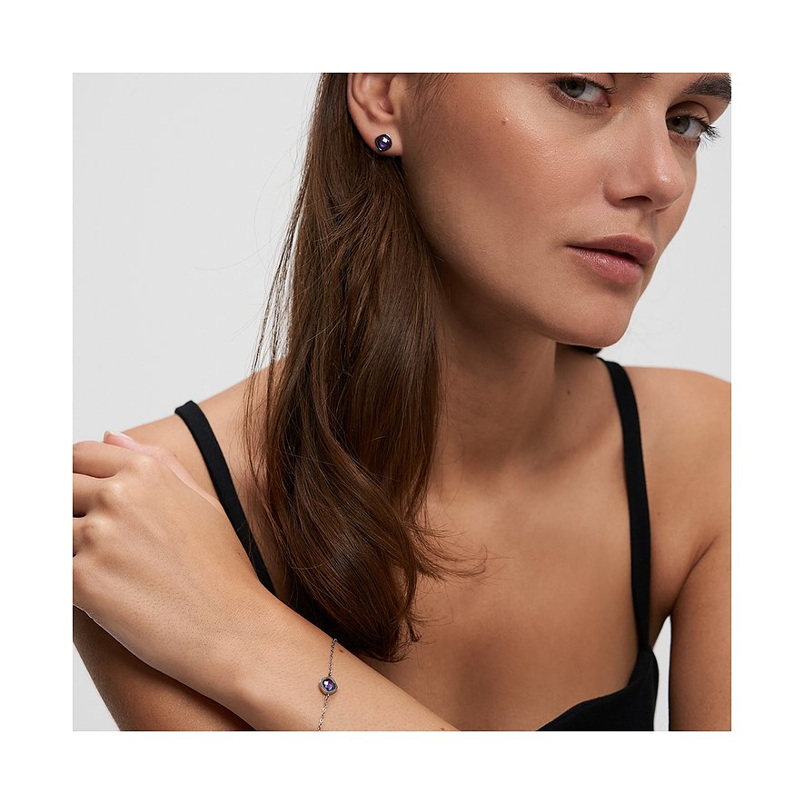 Gros plan d'une femme portant un bracelet Tamaris en acier inoxydable avec une pierre de zircone colorée.