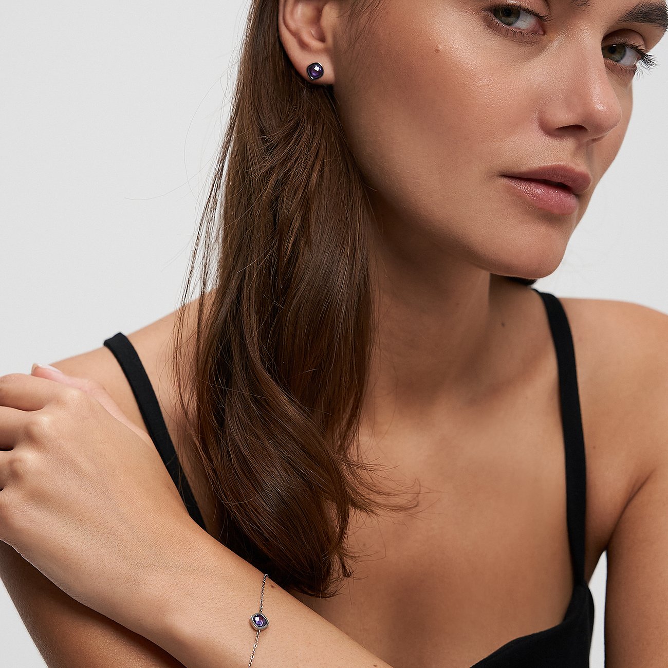 Gros plan d'une femme portant un bracelet Tamaris en acier inoxydable avec une pierre de zircone colorée.
