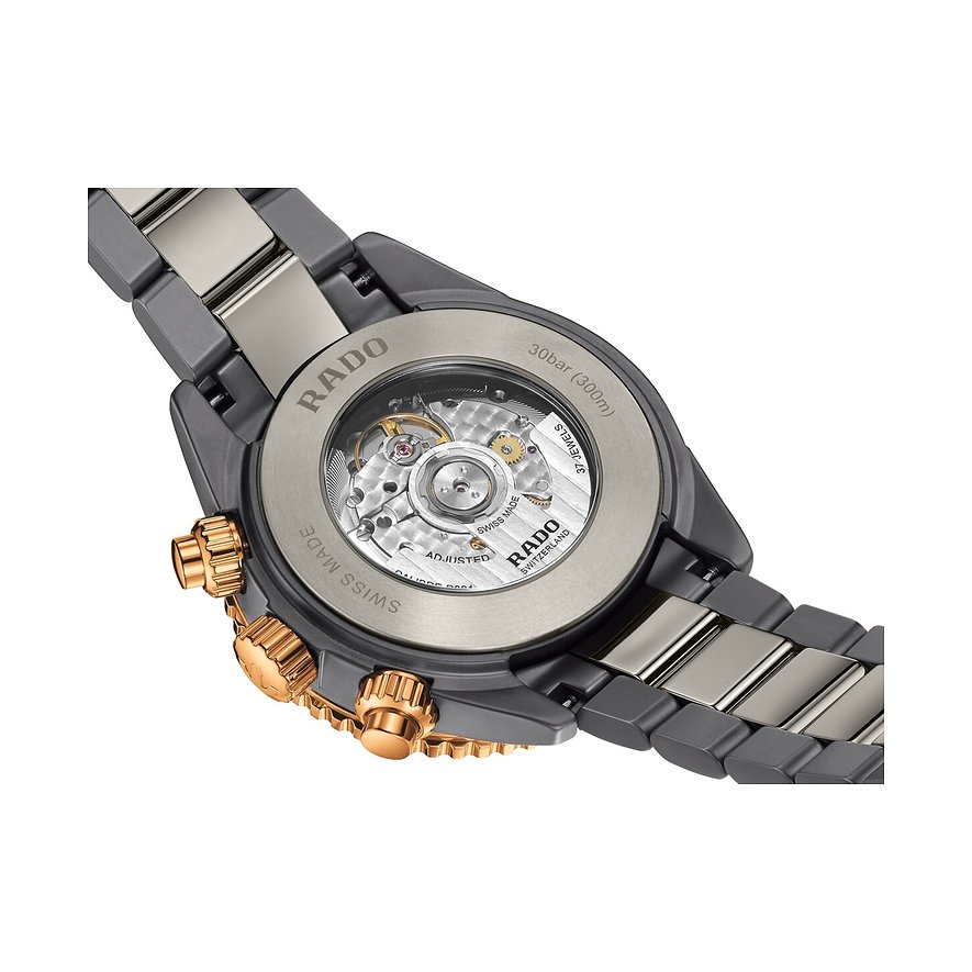Rado Herrenuhr aus Keramik: Rückseite mit sichtbarem Uhrwerk und seitlichen goldfarbenen Drückern und Krone.