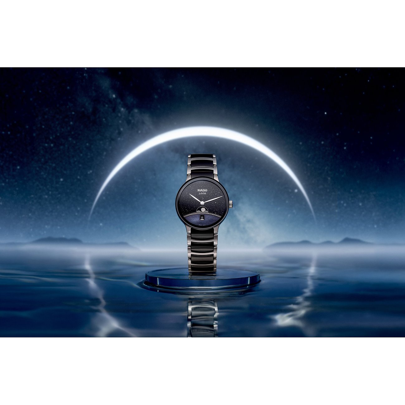 Rado Damenuhr aus Edelstahl mit Diamanten, stehend auf einem Podest im Wasser mit Mondfinsternis im Hintergrund.