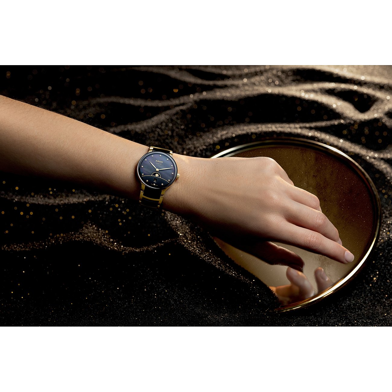 Eine Rado Damenuhr aus Edelstahl mit Diamanten am Handgelenk. Die Uhr hat ein dunkelblaues Zifferblatt.