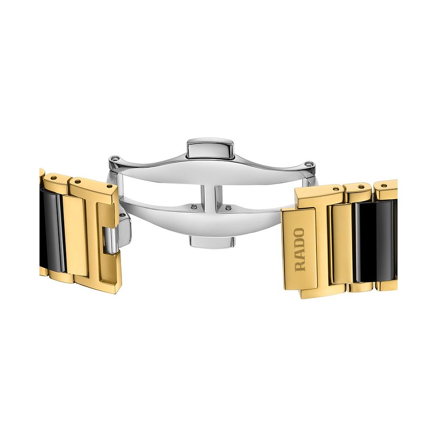 Nahaufnahme einer Schmetterlingsschließe aus glänzendem goldfarbenem Rado-Edelstahlarmband mit schwarzen Elementen.