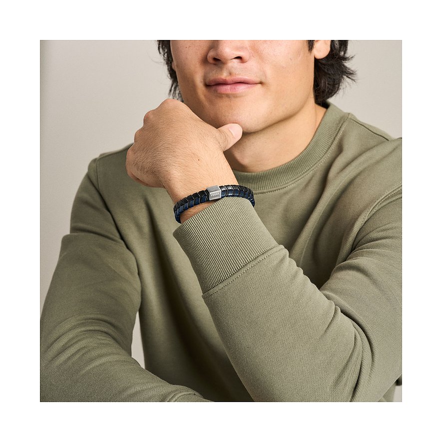Ein Mann trägt ein blaues Fossil Armband aus Leder und Edelstahl mit quadratischem Verschluss am rechten Handgelenk.