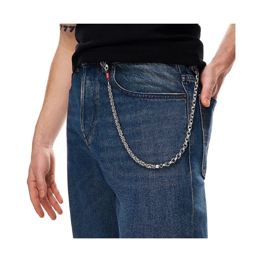 Gros plan d'une hanche masculine avec une chaîne Diesel en acier inoxydable fixée à un jean bleu.