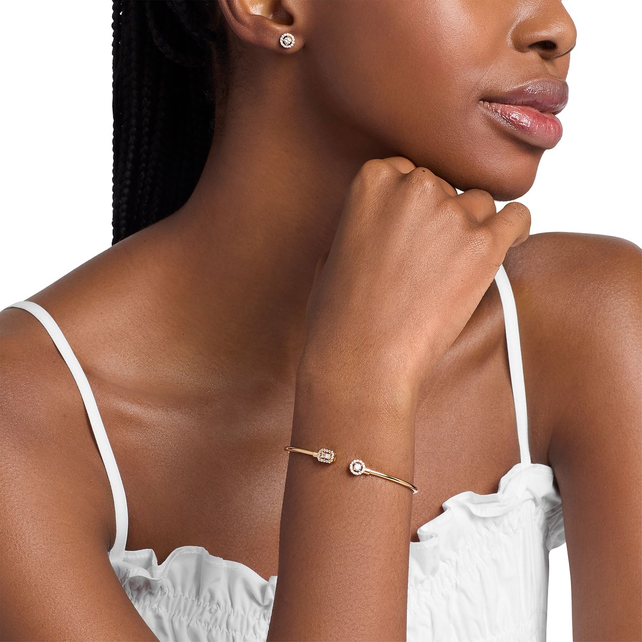 Model trägt das Michael Kors Schmuckset aus silberfarbenen Ohrsteckern und einem Armreif mit Zirkonia-Farbsteinen.