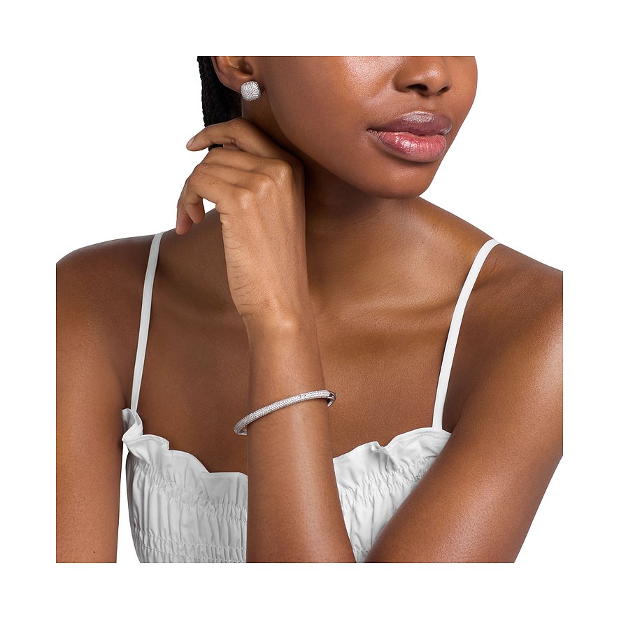 Ein Michael Kors Schmuckset-Modell trägt ein Armband und Ohrstecker aus Metall mit Zirkonia-Stein.