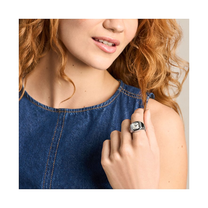 Nahaufnahme einer Frau, die eine Fossil Damenuhr aus Edelstahl als Ring am Finger trägt.