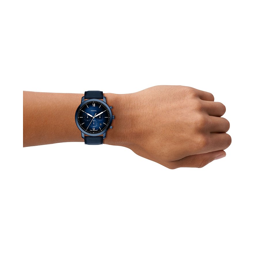 Eine Fossil Herrenuhr aus blauem Edelstahl mit dunkelblauem Zifferblatt und Lederarmband am Handgelenk eines Models.