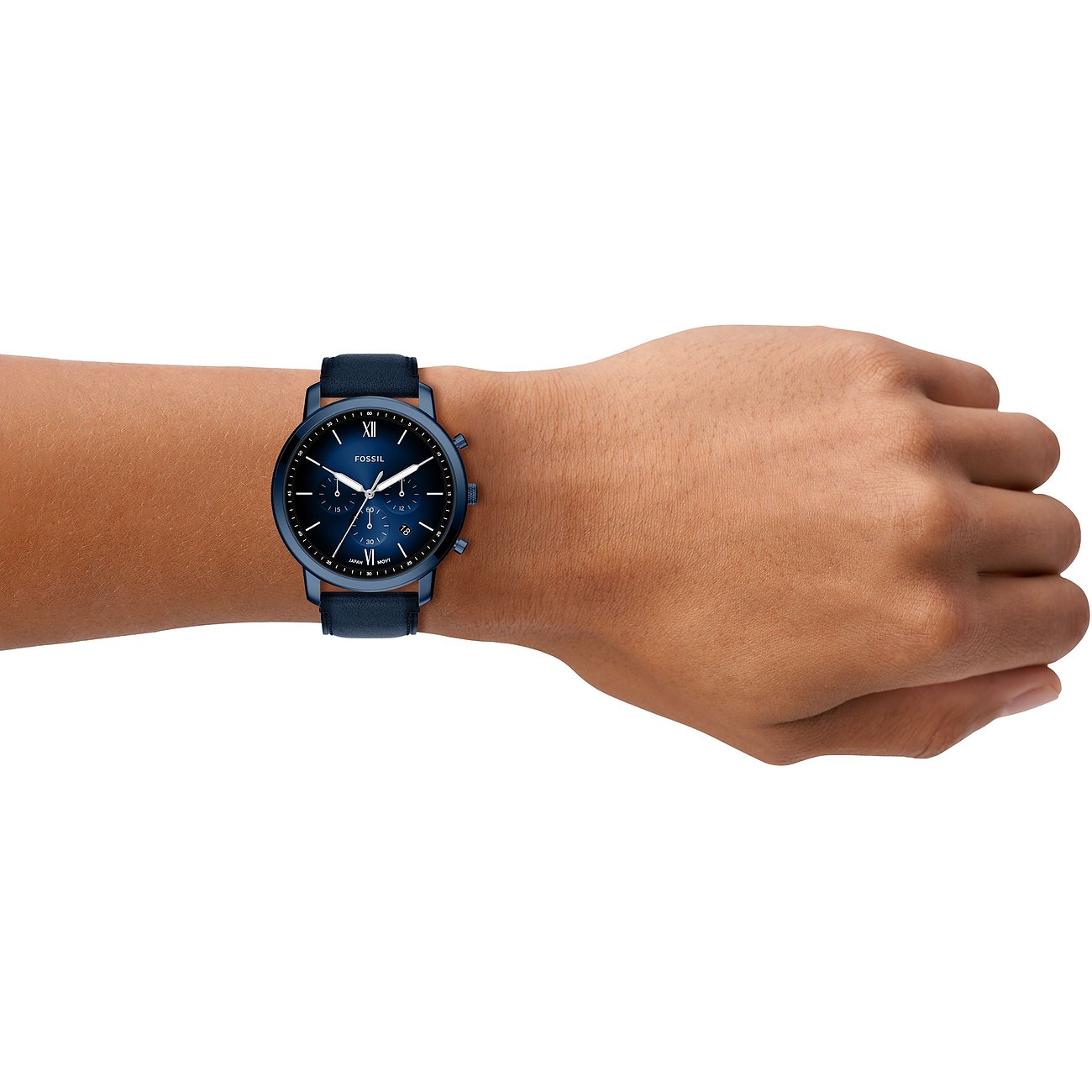 Eine Fossil Herrenuhr aus blauem Edelstahl mit dunkelblauem Zifferblatt und Lederarmband am Handgelenk eines Models.